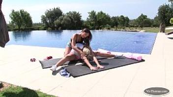 Blonde and brunette babes exercise by the pool