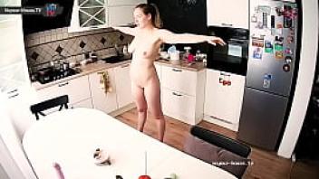 Real gorgeous female makes exercise at kitchen