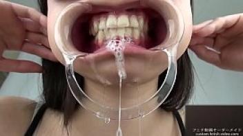 A woman shows her gums and sputs saliva